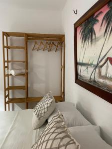 a bedroom with a bed and a painting on the wall at Casa De Vó in Amontada