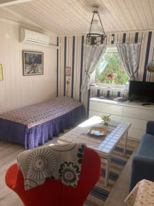 een slaapkamer met een bed, een tafel en een bank bij Lugnt och centralt in Strömstad