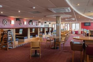 a dining room with tables and chairs and a bar at Weymouth Bay Holiday Static Caravan in Preston