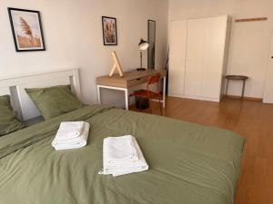 a bedroom with a green bed with towels on it at Apartament Słoneczny in Zamość