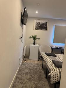 a room with a bed and a desk with a computer at Brigstock3 in Thornton Heath