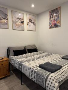 two beds in a bedroom with pictures on the wall at Brigstock3 in Thornton Heath