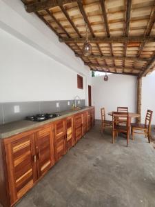 een keuken met houten kasten en een tafel met stoelen bij Chalé Brisa do Pontal in Fortim