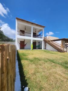 een wit huis met een hek en een tuin bij Chalé Brisa do Pontal in Fortim
