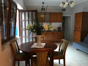 a dining room table with a vase of flowers on it at Nesa Beach Front Apartment in Poreč