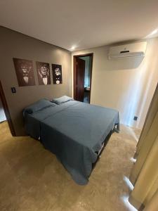 a bedroom with a bed and a wall with pictures at Frances - casa do Lago in Marechal Deodoro +16 photos