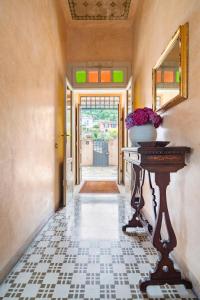 a hallway with a table with a vase of flowers on it at Villa Cecilia - pieds dans l'eau in Sulzano