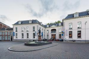 een groot wit gebouw met een standbeeld ervoor bij Luxe woonboot in de natuur aan doorgaand vaarwater in Leeuwarden