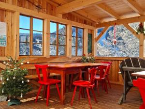 a dining room with a table and red chairs at Haus Enzian in Hinterstoder