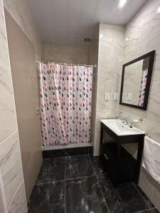 a bathroom with a shower with a sink and a mirror at El Atardecer in Trapiche +4 photos