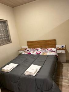 a bedroom with a bed with two towels on it at El Atardecer in Trapiche