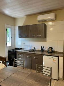 a kitchen with wooden cabinets and a table with chairs at El Atardecer in Trapiche