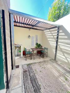 a patio with a table and chairs under awning at Buen Descanso 2 in San Pedro