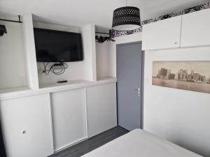 a living room with white cabinets and a flat screen tv at PapayaCalais in Calais