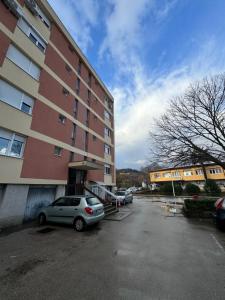 a car parked in a parking lot next to a building at Apartman Jojo in Čapljina +1 photo