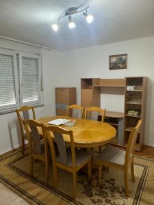 a dining room with a wooden table and chairs at Apartman Jojo in Čapljina