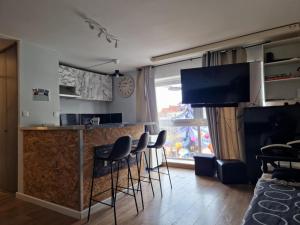 a kitchen with a bar with stools in a room at PapayaCalais in Calais +4 photos