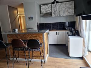 a kitchen with a counter and two stools in it at PapayaCalais in Calais