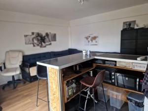 a living room with a bar with stools and chairs at PapayaCalais in Calais