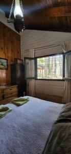 ein Schlafzimmer mit einem großen Bett und einem Fenster in der Unterkunft Cálida casa de montaña in Potrerillos