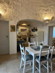 a kitchen and dining room with a table and chairs at Trullo in vigna in Cisternino +45 photos