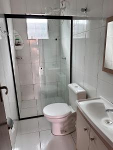 a white bathroom with a toilet and a shower at Refúgio do Churrasco in Matinhos +14 photos