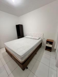 a bedroom with a bed and a night stand at Refúgio do Churrasco in Matinhos