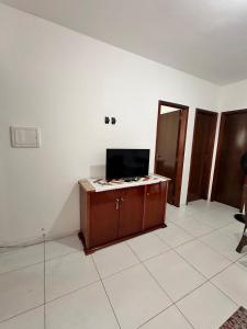 an empty room with a tv and a desk in it at Refúgio do Churrasco in Matinhos