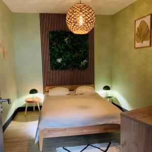 a bedroom with a bed with a plant on the wall at Loft Moderne Avec Jacuzzi Roft top Le B in Baccarat