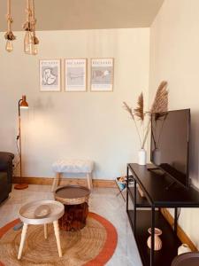 a living room with a tv and a table at Loft Moderne Avec Jacuzzi Roft top Le B in Baccarat