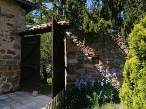 an open gate to a stone wall with purple flowers at Chambres d'Hôtes Le Grand Chaleat in Éclassan +31 photos