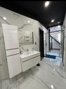 a white bathroom with a sink and a mirror at Loft Moderne Avec Jacuzzi Roft top Le B in Baccarat +28 photos