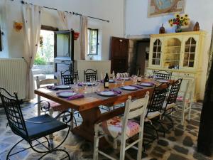 a large wooden table with chairs and wine glasses at Chambres d'Hôtes Le Grand Chaleat in Éclassan