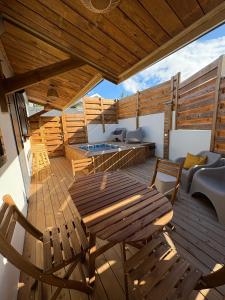 a wooden deck with a wooden table and chairs at Villa O'CAMPÊCHE in Rivière-Salée