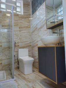a bathroom with a toilet and a sink at Résidence DELIA in Diego Suarez