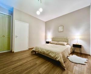 a bedroom with a bed and two lamps and a door at ROUERGAT's LITTLE GITE in Villefranche-de-Rouergue