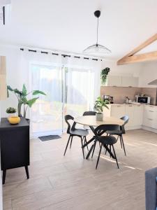 a kitchen and dining room with a table and chairs at À l'ombre du pin in Entraigues-sur-la-Sorgue
