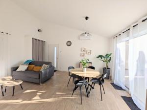 a living room with a table and a couch at À l'ombre du pin in Entraigues-sur-la-Sorgue +6 photos