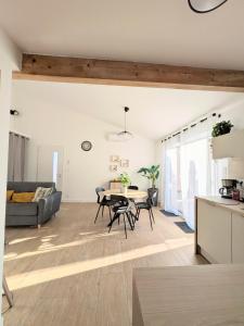 a kitchen and living room with a table and chairs at À l'ombre du pin in Entraigues-sur-la-Sorgue
