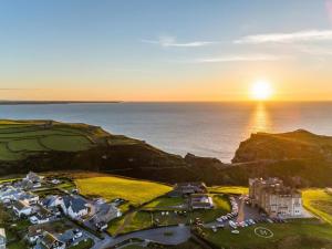 an aerial view of a resort with the sun setting over the ocean at 3 Bed in Tintagel oc-e32938 in Tintagel
