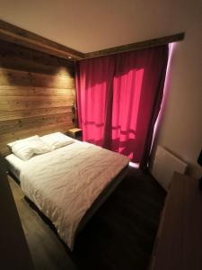 a bedroom with a bed with a red curtain at Temples Du Soleil Tikal Appartements VTI in Val Thorens