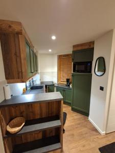 a kitchen with green cabinets and a green refrigerator at Temples Du Soleil Tikal Appartements VTI in Val Thorens