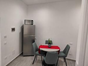 a kitchen with a table with chairs and a refrigerator at Agrigento Zefiro Rooms in Agrigento