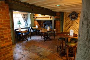 a restaurant with wooden tables and chairs in a room at Monk and Tipster in Towcester