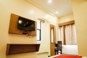 a room with a flat screen tv on the wall at Qubehotelinn in Cochin