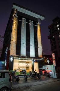 a building with motorcycles parked in front of it at night at Qubehotelinn in Cochin