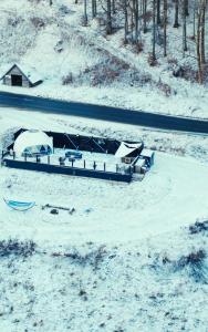 杜什尼基-兹德鲁伊Całoroczny Apartament Jacuzzi Zieleniec Goat Glamp的路边停着一艘被雪覆盖的船