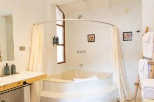 a white bathroom with a tub and a sink at Tariq Sacred Valley in Urubamba +135 photos