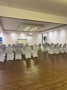 Ein leerer Raum mit weißen Stühlen und einer Projektionsfläche in der Unterkunft Hotel Origenes in Vallenar + 40 Fotos