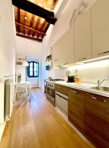 a large kitchen with wooden floors and white cabinets at La Torre di Canonica in Colle di Val d'Elsa